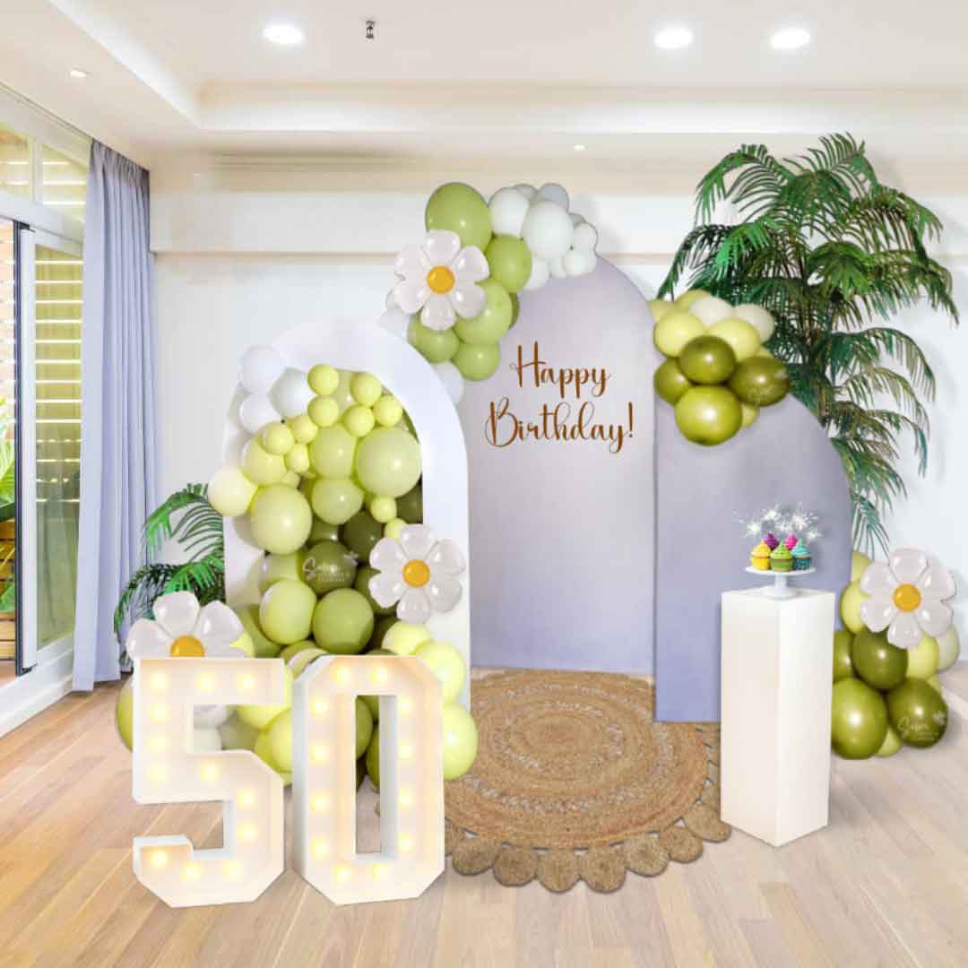 A room decorated with a Balloon decoration with 3 panels, jute rug, plams, cake stand, marquee numbers. Oregon Balloon decor