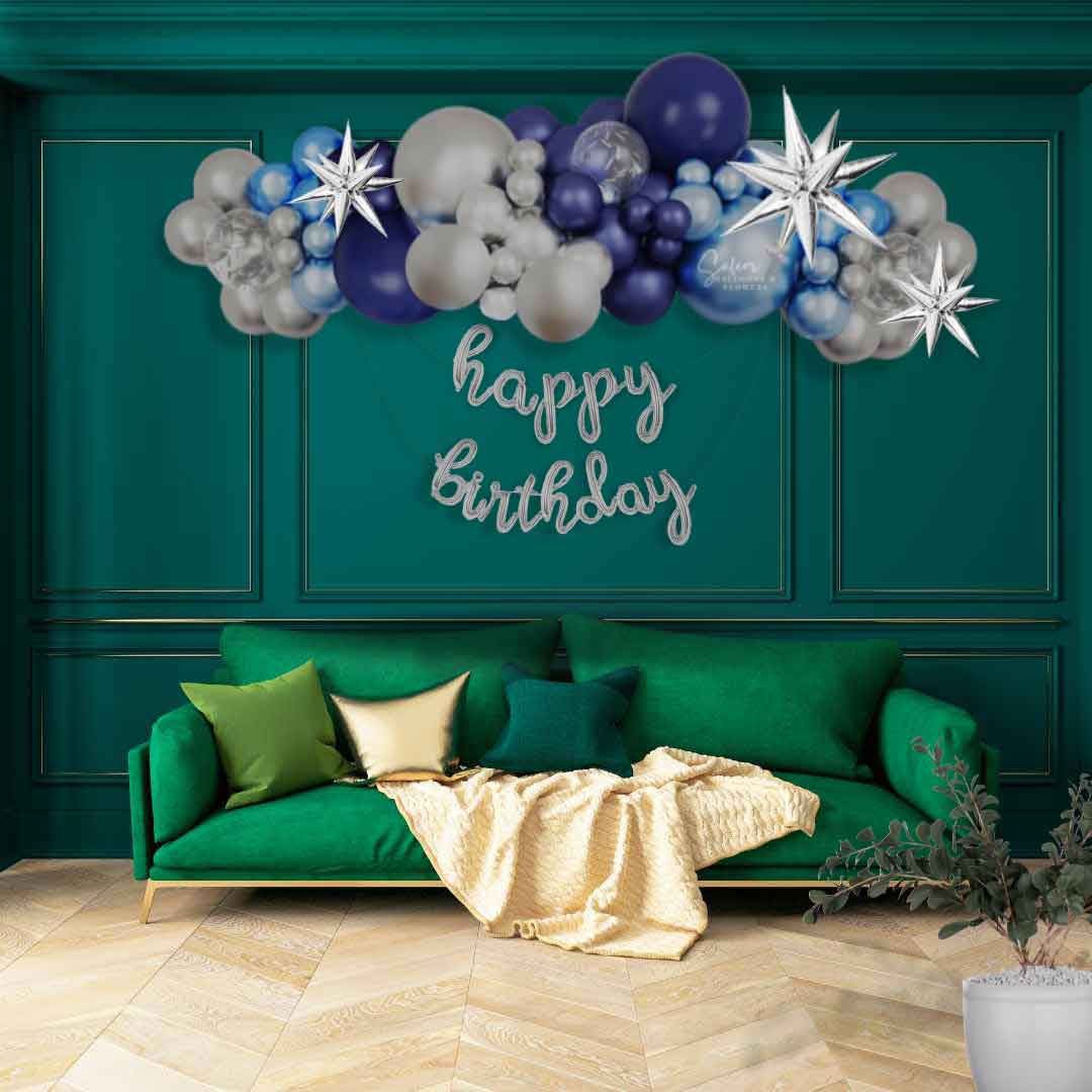 8Ft long organic balloon garland in blue and silver on a green wall with a happy birthday balloon banner. Oregon Balloon decor.