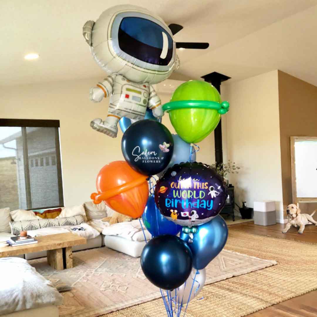 tall ceiling Living Room with a 7 ft tall balloon bouquet in the center. Featuring an astronaut balloon with balloon planets. Oregon Balloon delivery.  