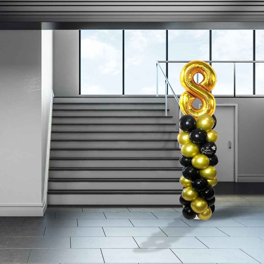 A Number balloon column in gold and black in front of a staircase. Oregon Balloon Decor. 