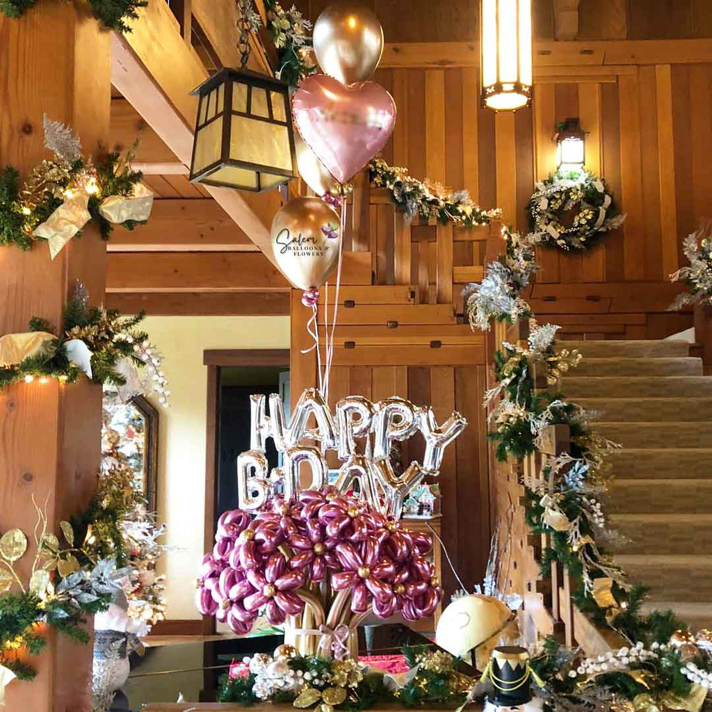 Daisy Flower Balloon Bouquet in pink and gold, featuring a Happy Birthday sign and a set of helium balloons standing on top of a piano in a living room. Oregon Balloon decor.