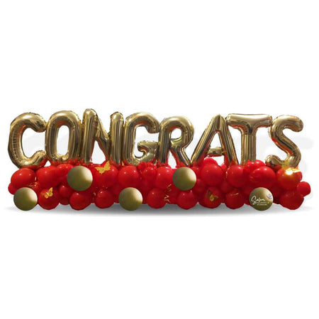 Balloon table runner spelling CONGRATS with gold balloon letters on a balloon garland. Salem Oregon Balloon decor delivery