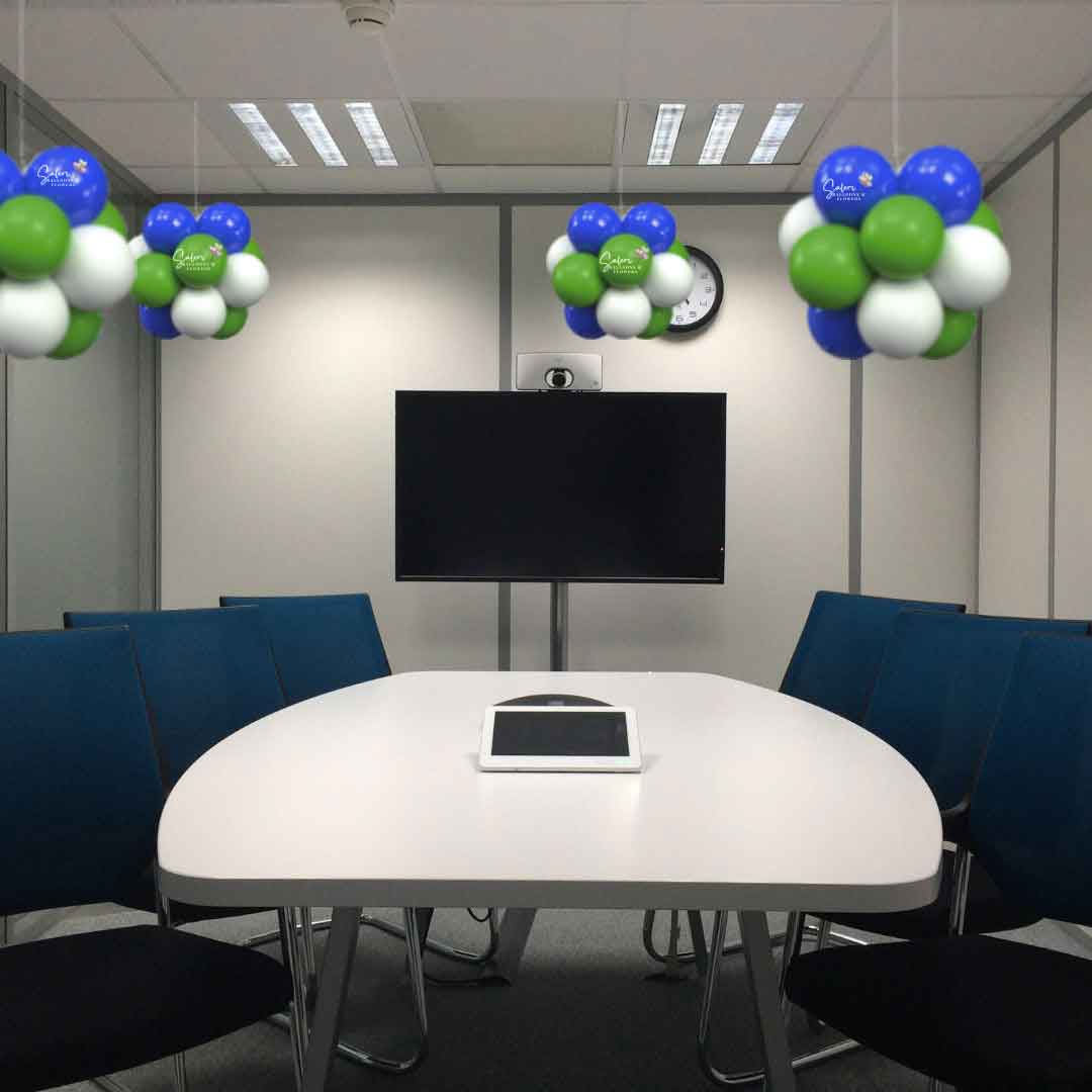 Conference room ceiling decorated with cluster balloon pom poms in green, blue and white. Oregon Balloon decor.