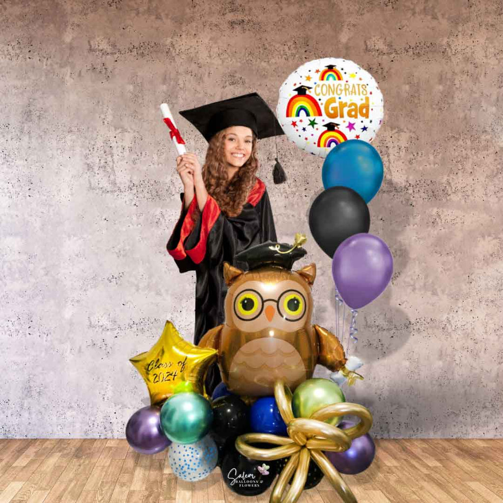 A grad girl standing next to a colorful balloon bouquet, featuring a large Owl shaped balloon holding her diploma and a set of helium balloons with a 