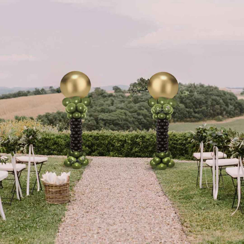 2 Balloon columns with a curvy form and round topper in gold and brown framing a wedding ceremony in a yard. Oregon Balloon Decor