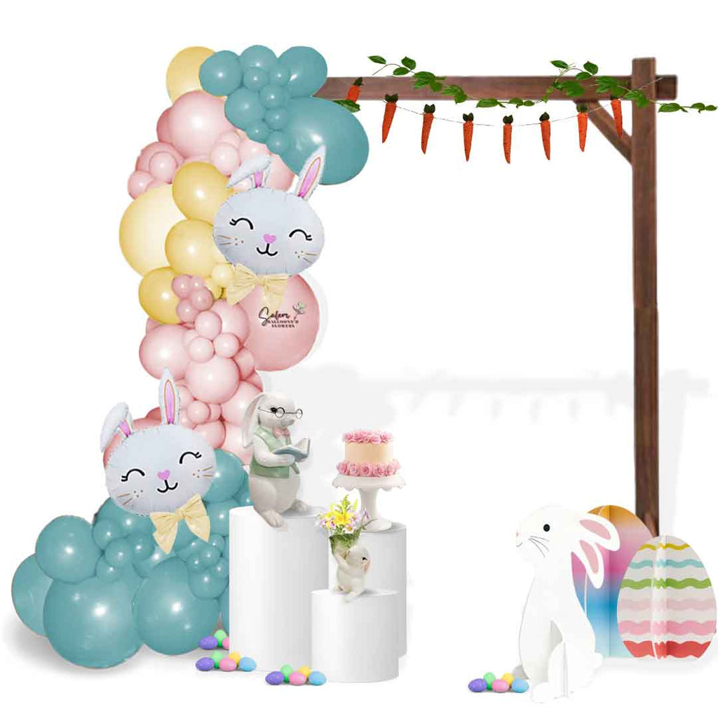 Easter-themed organic balloon garland in pastel colors fixed to a wooden frame and decorated with bunny props, flowers and easter eggs. Salem Oregon balloon decor