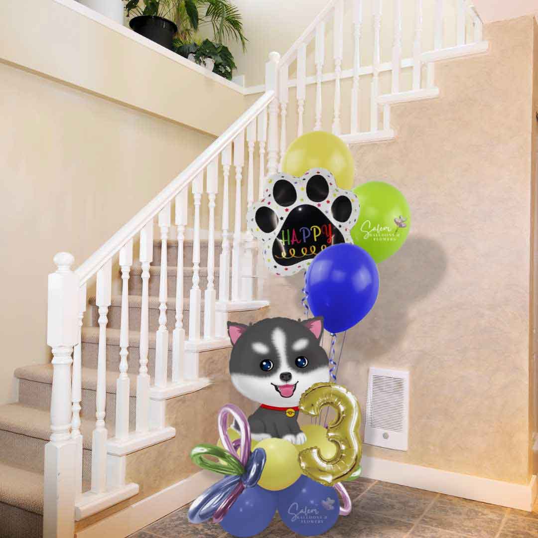 A Husky dog themed balloon bouquet. Featuring a husky shaped balloon, Balloon numbers, and helium balloons in front of a staircase. Oregon balloon delivery. 