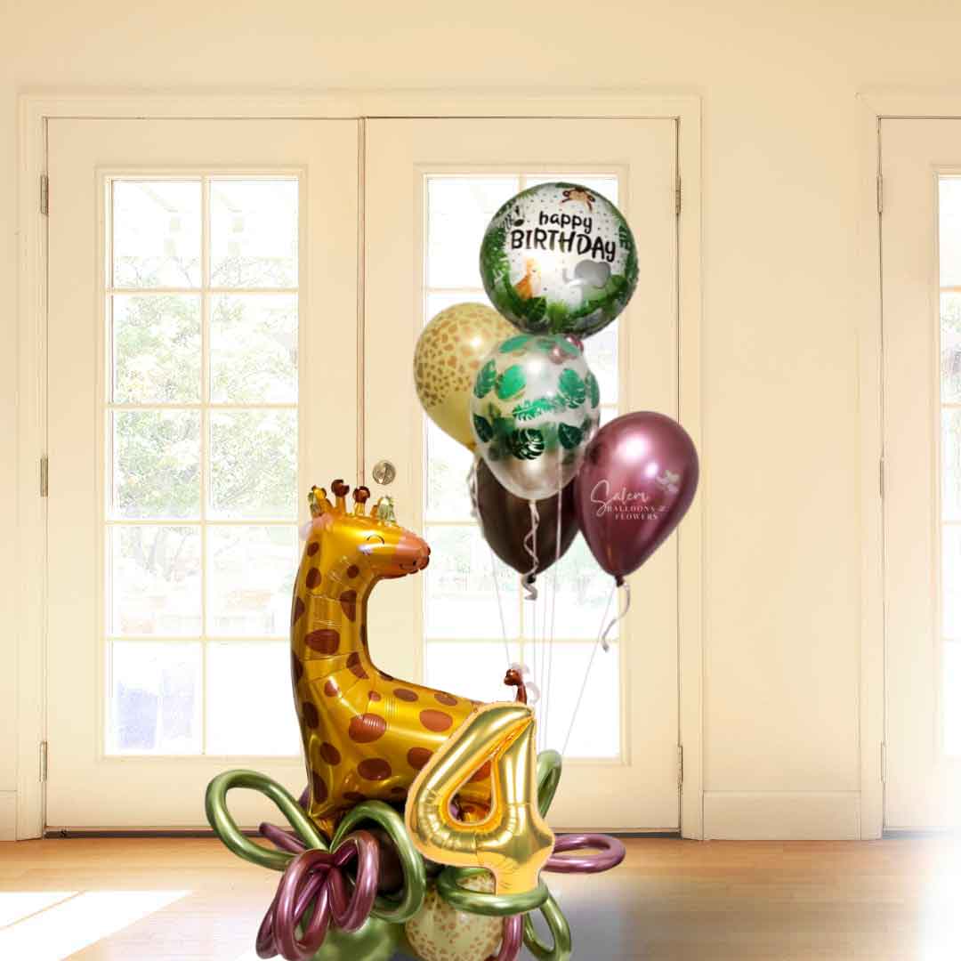 A Safari themed balloon bouquet featuring a large Giraffe balloon standing on a balloon base with helium balloons, standing in front of a white french door. Balloon delivery  Salem Oregon