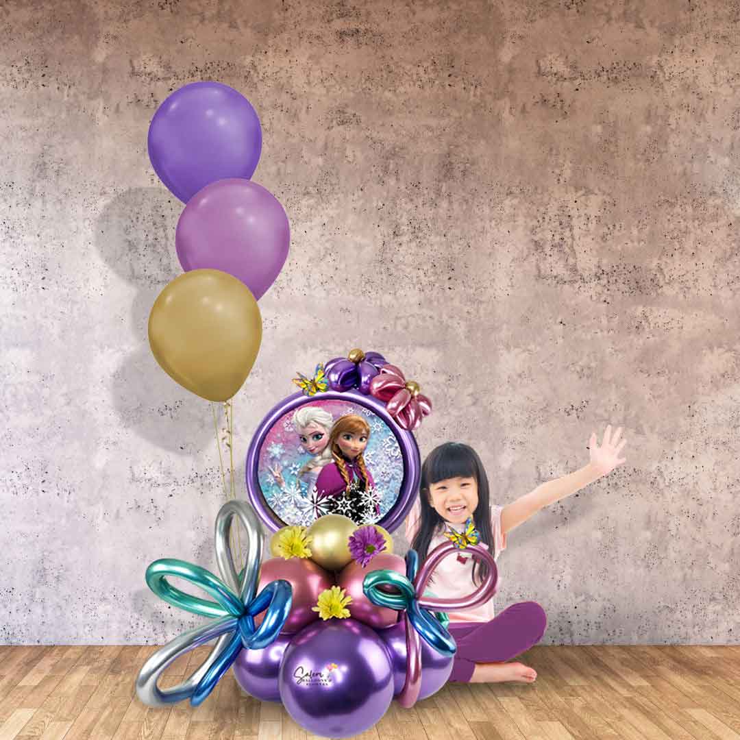 little girl sitting next to a Frozen themed balloon marquee decorated with flowers and a helium balloon bouquet. Balloons Salem Oregon. Balloon delivery