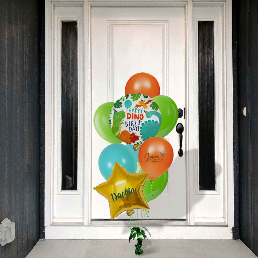 A white front door with a Dinosaur themed balloon bouquet. In a vibrant orange, green and caribbean blue palette. Featuring a 