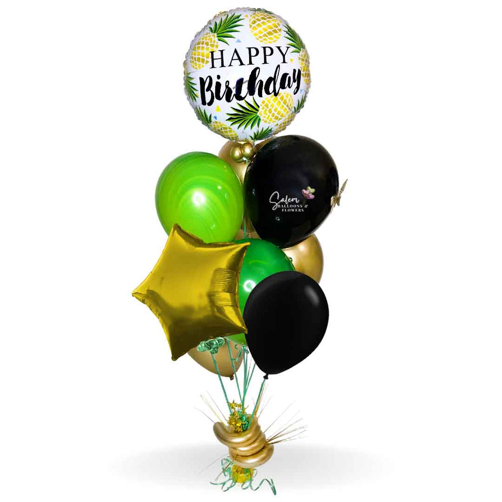 HBD tropical balloon bouquet. Featuring a pineapple themed Mylar balloons with a Happy Birthday message and a set of bright colored helium balloons, anchored to a decorated weight. Balloons Salem Oregon and nearby cities.