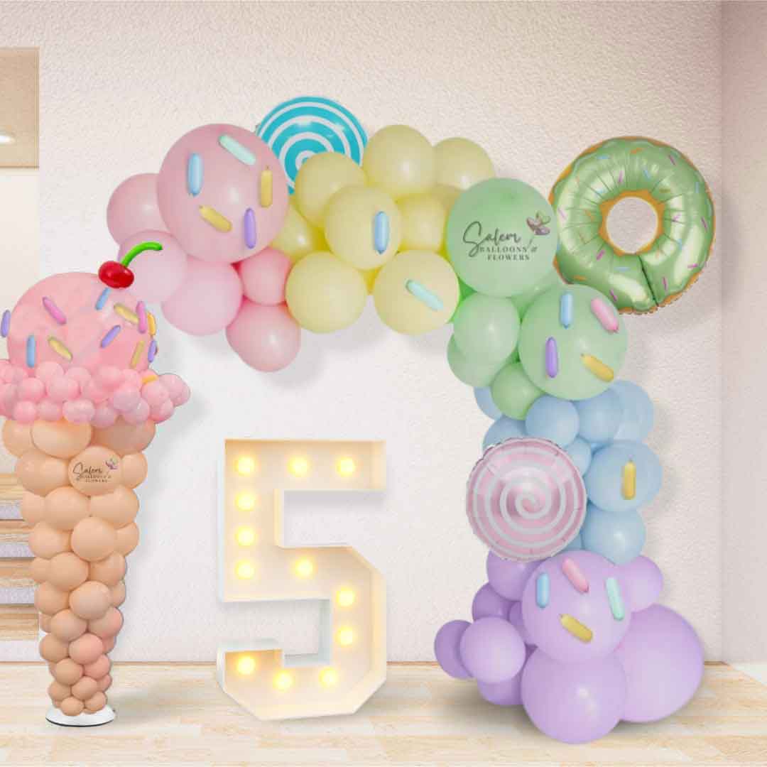 Ice Cream balloon column with balloon sprinkles and a cherry next to an organic balloon garland y pastel colors. Oregon Balloon decor. 