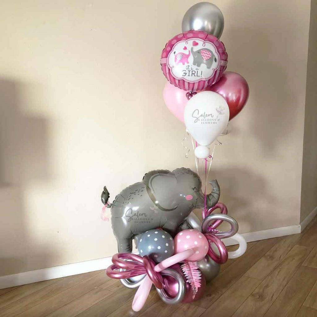 A Elephant themed balloon bouquet in a Pink and Gray color palette. Featuring a large elephant balloon holding a helium-filled balloon bouquet with a 