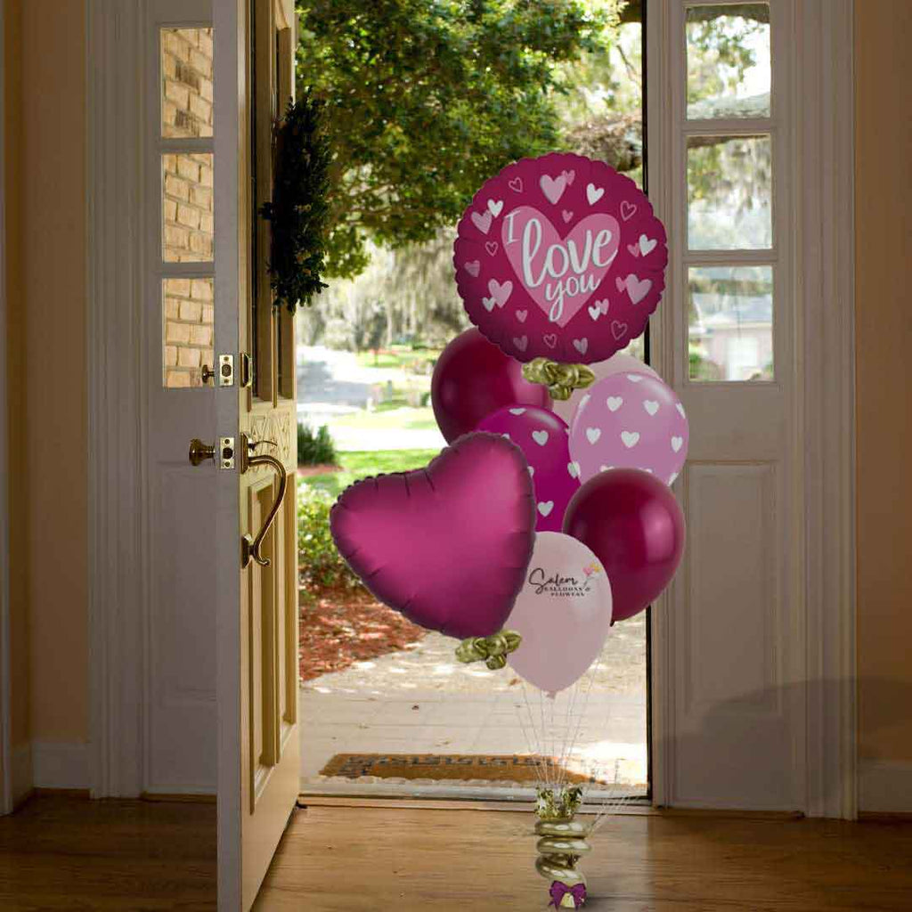 Pomegranate heart helium balloon bouquet. In various shades of pink standing in front of a entry door. Valentines day balloon delivery. Salem Oregon