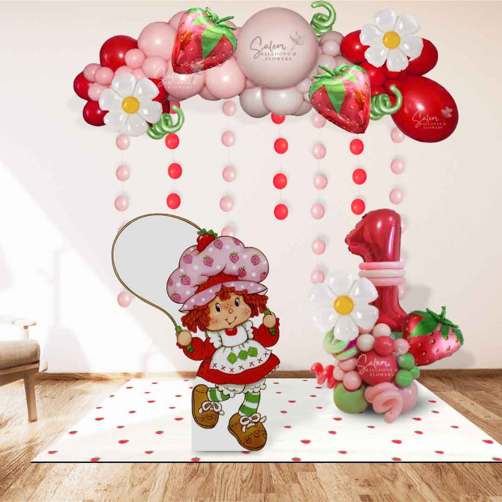 Strawberry Shortcake themed balloon decoration, featuring a balloon garland, number balloon bouquet, and one cutout in shades of in pinks, red and a touch of green. Balloon Decor. Oregon.