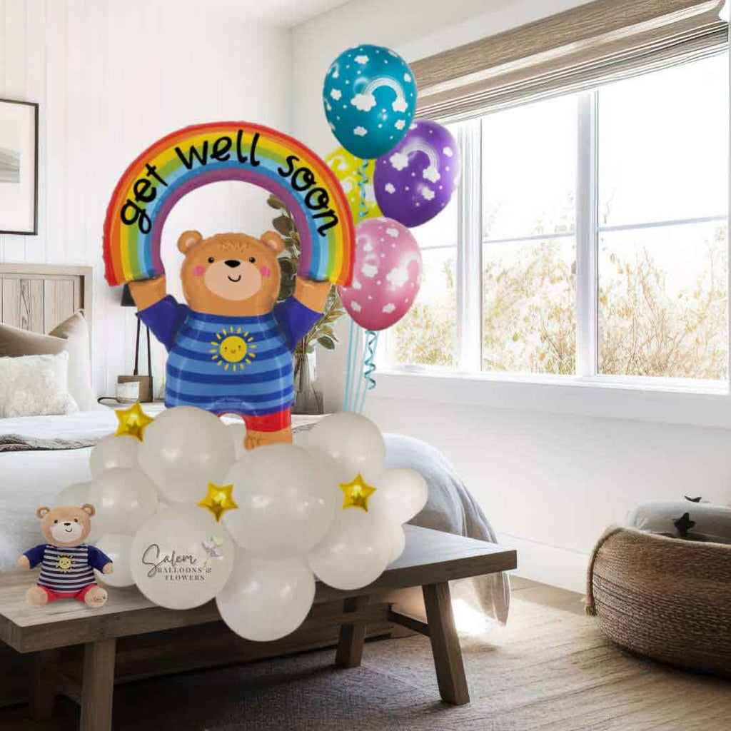 A charming teddy bear balloon holding a rainbow with a heartfelt 