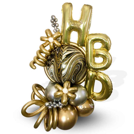 HBD Balloon bouquet. Luxury Balloon Arrangement. Featuring golden HBD letters, a marbled orbz balloon in gold, silver and black colors and decorated with golden flowers and curly balloons. Oregon  Balloon Delivery.