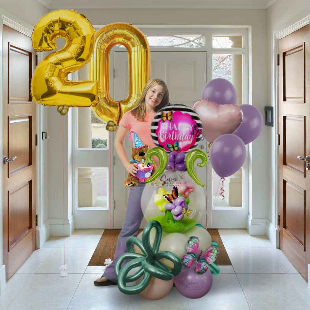 A girl holding balloon gift and balloon numbers with plush. Oregon Balloon Delivery.